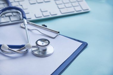 Masa, bir reçete yazma hastanede çalışan doktor stetoskop Pano ve dizüstü bilgisayar ile. Sağlık ve tıp kavramı, arka plan, seçici odak test sonuçlarında
