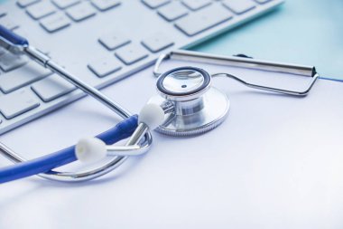 Masa, bir reçete yazma hastanede çalışan doktor stetoskop Pano ve dizüstü bilgisayar ile. Sağlık ve tıp kavramı, arka plan, seçici odak test sonuçlarında