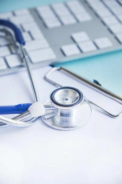 Estetoscopio con portapapeles y computadora portátil en el escritorio, Doctor trabajando en el hospital escribiendo una receta. Salud y concepto médico, resultados de las pruebas en el fondo, enfoque selectivo —  Fotos de Stock