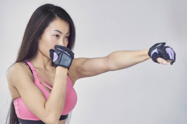 Asyalı kadın egzersiz eller şal ile boks. Güzellik ve doğal makyaj spor sutyen kıyafeti.