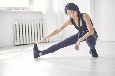 fitness, spor, eğitim, spor ve yaşam kavramı - kulaklık ile genç kadın spor salonunda germe