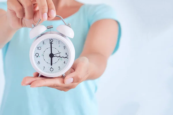 Pequeno despertador azul nas mãos da mulher, o conceito de economizar tempo — Fotografia de Stock