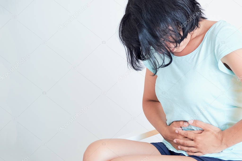 Closeup ill young woman on sofa. concept suffering from abdominal pain