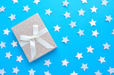 Düz sarılmış ve yay üzerinde kopya alanı ile mavi arka plan ile dekore edilmiş hediye yatıyordu