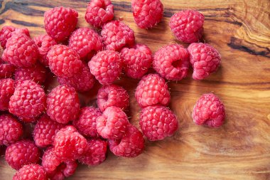 Siyah arka plan üzerine taze organik ahududu. bir ahşap tahta üzerinde çilek