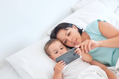 Anne ve bebek birlikte yatakta yatmak ve selfies almak