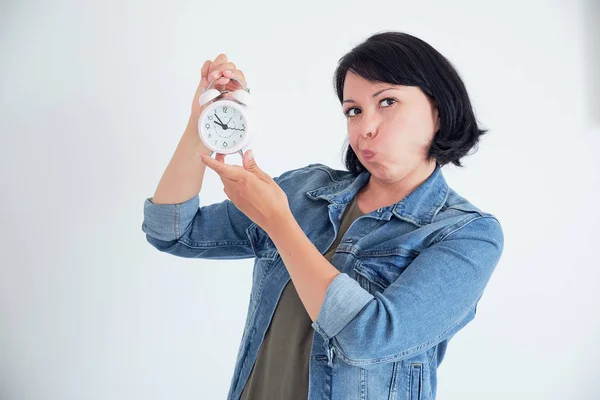 surprised young woman with clock wondering eyes. stressed concept