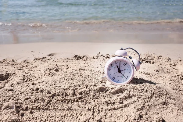 Tempo de férias. Relógio de alarme na areia — Fotografia de Stock