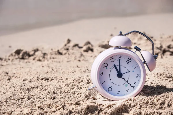 Tempo de férias. Relógio de alarme na areia — Fotografia de Stock