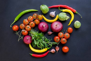 Kaşık ve domates karanlık antika arka plan üzerinde renkli baharat. Üstten görünüm. Yemek ve mutfak malzemeleri. Vegan veya diyet gıda kavramı. Serbest metin alanı ile arka plan düzeni.
