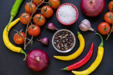 Kaşık ve domates karanlık antika arka plan üzerinde renkli baharat. Üstten görünüm. Yemek ve mutfak malzemeleri. Vegan veya diyet gıda kavramı. Serbest metin alanı ile arka plan düzeni.