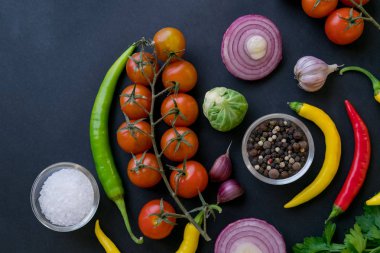 Kaşık ve domates karanlık antika arka plan üzerinde renkli baharat. Üstten görünüm. Yemek ve mutfak malzemeleri. Vegan veya diyet gıda kavramı. Serbest metin alanı ile arka plan düzeni.