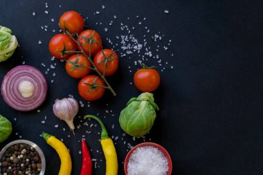 Kaşık ve domates karanlık antika arka plan üzerinde renkli baharat. Üstten görünüm. Yemek ve mutfak malzemeleri. Vegan veya diyet gıda kavramı. Serbest metin alanı ile arka plan düzeni.