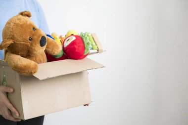 Erkek gönüllü holding bağış kutusu ile eski oyuncaklar.