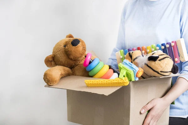 Erkek gönüllü holding bağış kutusu ile eski oyuncaklar.