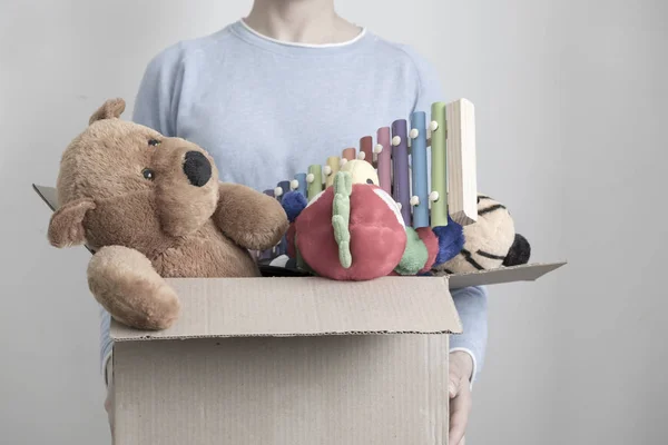 Maschio volontario in possesso di scatola di donazione con vecchi giocattoli . — Foto Stock