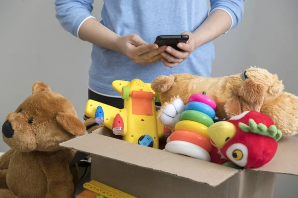 Волонтер держит коробку для пожертвований со старыми игрушками . — стоковое фото
