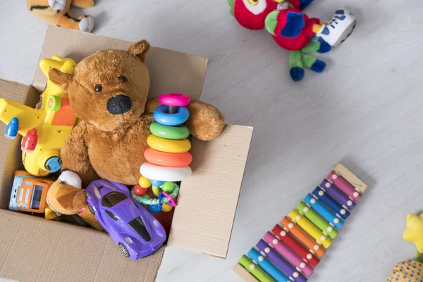 Doos met speelgoed op de vloer. Teddy bear in vak, vintage Toon. charitatieve bijdragen. donatie. weldadigheid. — Stockfoto