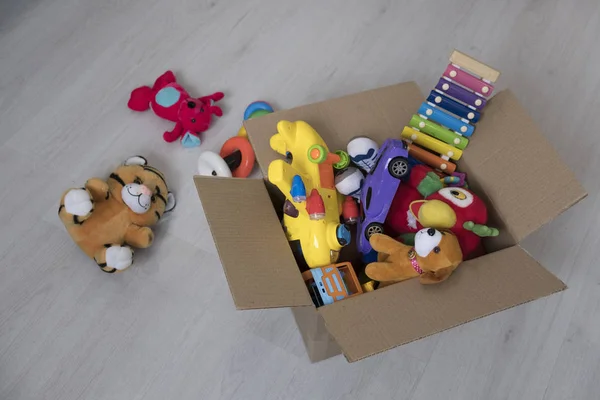 Doos met speelgoed op de vloer. Teddy bear in vak, vintage Toon. charitatieve bijdragen. donatie. weldadigheid. — Stockfoto