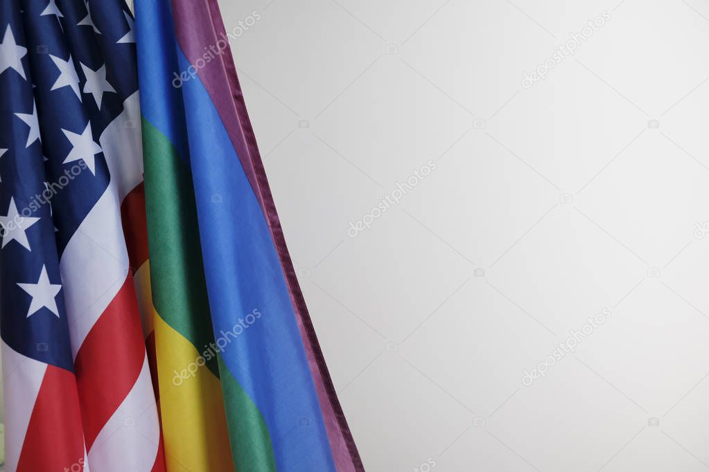 closeup of a gay pride flag and a flag of the United States of America