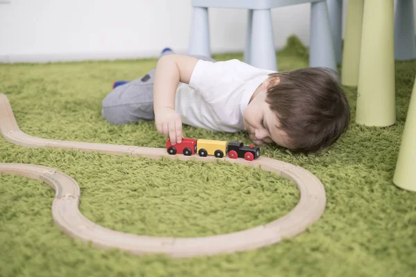 Μικρό παιδί στην αίθουσα πολύχρωμο παιδιά σε ένα νηπιαγωγείο ή την προσχολική ηλικία. παιδί αγόρι παίζει με δείκτες παιχνίδια στο σπίτι. Ασίας μωρό 2 ετών παίζει μόνος σε ένα καταπράσινο χαλί. — Φωτογραφία Αρχείου