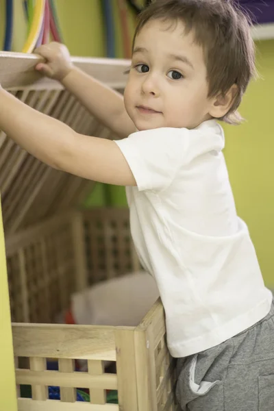 Gyönyörű ázsiai kisfiú fehér doboz, játékok — Stock Fotó