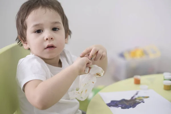 젖은 아기 물티슈입니다. 5 년 오래 된 소년 그의 손에서 페인트를 지워 버리고. — 스톡 사진