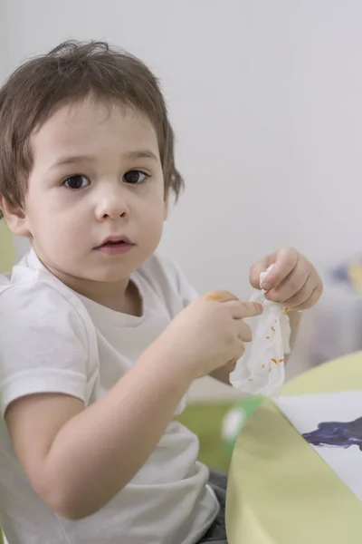 Wet baby wipes. 5 year old boy wipes the paint off his hands. — Stock Photo, Image