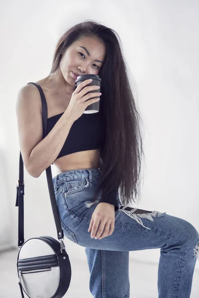 Молодая довольно улыбающаяся азиатская корейская девушка в современной одежде моды на белом фоне, образ жизни людей концепция крупным планом — стоковое фото