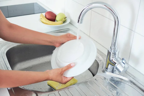 有魅力的年轻女人的形象是一边洗碗一边在家里打扫卫生 — 图库照片