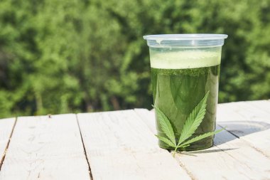 Ahşap arka plan üzerinde sağlıklı esrar güler yüzlü. Doğal ek, detoks ve sağlıklı yaşam