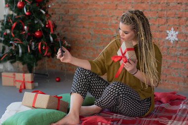 mutlu genç güzel kız telefonda konuşurken ya da onun hediye ile selfie alarak. Noel için alışveriş. hediye için bir teşekkür mesajı yazmak için akıllı telefon kullanır.