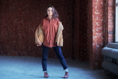 Hippi kız gözlük ve siyah bere ışık gri arka plan üzerinde dans