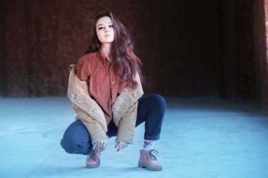 Hippi kız gözlük ve siyah bere ışık gri arka plan üzerinde dans