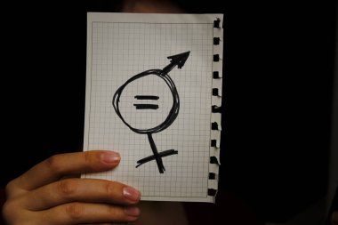 bir parça kağıt cinsiyet eşitliği içinde çizilmiş bir simgesi ile gösterilen sokakta genç bir beyaz kadın portre