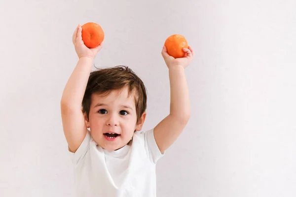 Lindo Niño Sostiene Mandarina Aislado Sobre Blanco — Foto de Stock