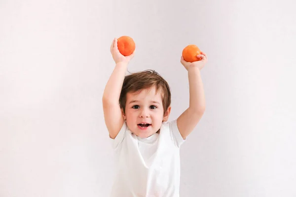 Lindo Niño Sostiene Mandarina Aislado Sobre Blanco — Foto de Stock