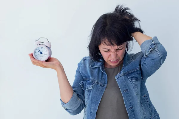 Asian woman holding a pink alarm clock on a white background. the concept of time management. get control of your life