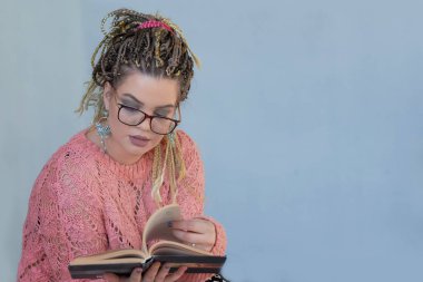 bir kitap okuma gözlük ile güzel bir genç kadının portre.