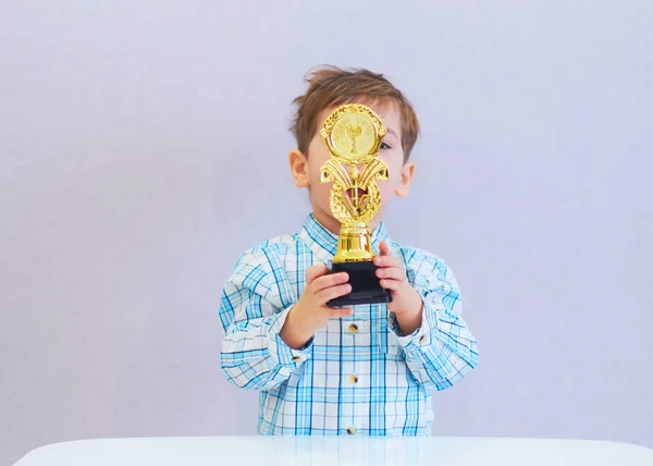 Divertido chico edad tres años de edad, celebración en la celebración de un trofeo — Foto de Stock