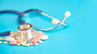 ilaç ve mavi arka planda bir stetoskop. metin için boş alan. güvenli ilaçlar