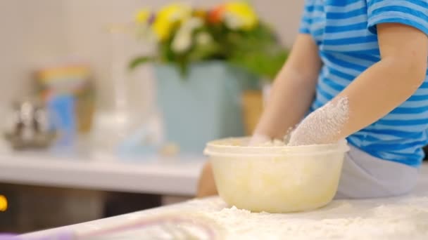 Pequeño niño preparando la masa en la mesa y estornuda. Pequeño bebé jugando con harina. Baker prepara la masa — Vídeos de Stock