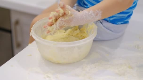 Criança preparando massa na mesa e espirra. Um bebé a brincar com farinha. Baker prepara a massa — Vídeo de Stock