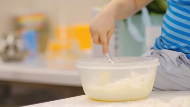 Bambino che prepara la pasta sul tavolo e starnutisce. Piccolo bambino che gioca con la farina. Baker prepara l'impasto — Video Stock