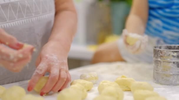 Babcia i wnuk bawią się razem. szczęśliwą rodziną. Starszy kobieta i mały chłopiec Kneading ciasto w mąka na tabela — Wideo stockowe