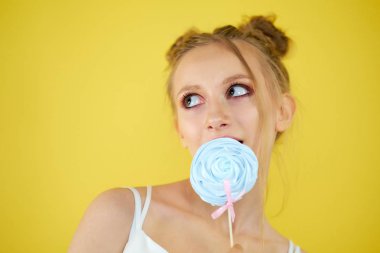 sarı parlak arka planda şeker ile genç kız. güzel makyaj,