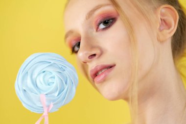 sarı parlak arka planda şeker ile genç kız. güzel makyaj,