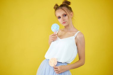 sarı parlak arka planda şeker ile genç kız. güzel makyaj,