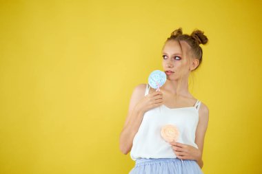 sarı parlak arka planda şeker ile genç kız. güzel makyaj,