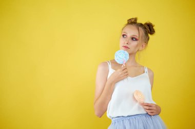 sarı parlak arka planda şeker ile genç kız. güzel makyaj,